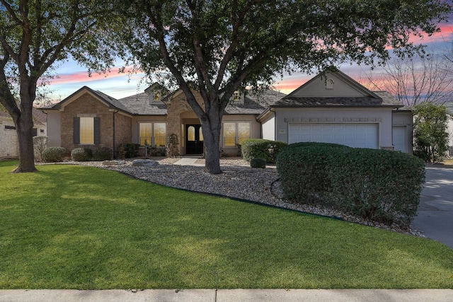 ranch-style house featuring a garage, a front lawn, and stucco siding