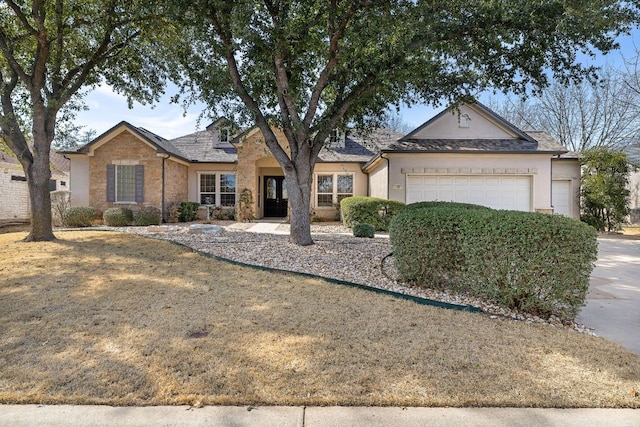 ranch-style home featuring a garage and stucco siding