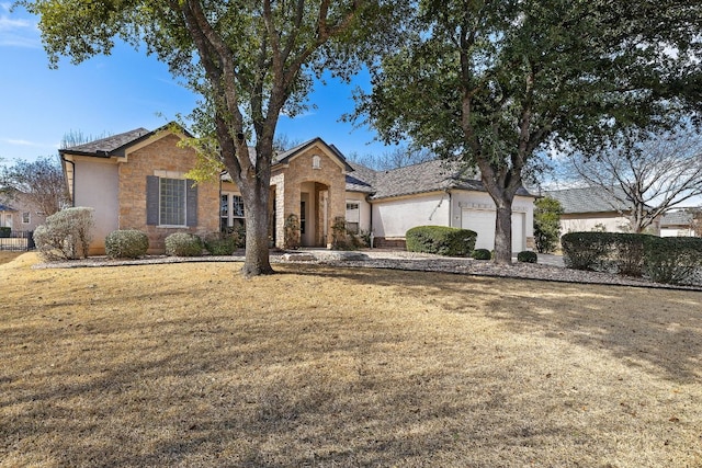 ranch-style home featuring stone siding, an attached garage, and a front lawn