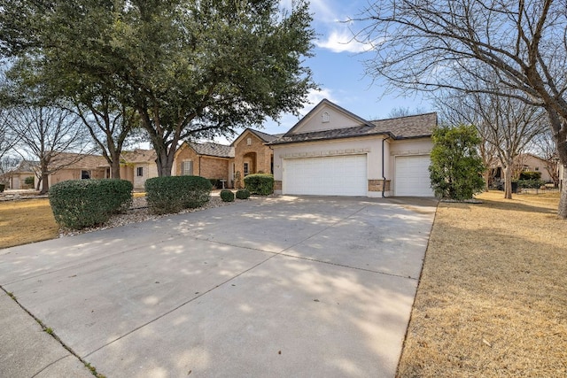 ranch-style home featuring a garage, stucco siding, concrete driveway, and brick siding