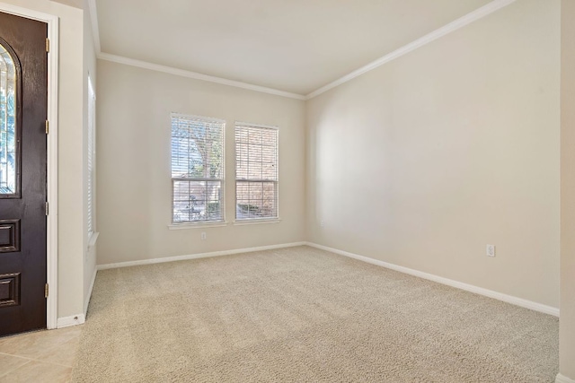 spare room with baseboards, ornamental molding, and light colored carpet