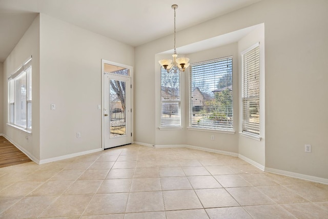 unfurnished dining area with light tile patterned floors, baseboards, and an inviting chandelier