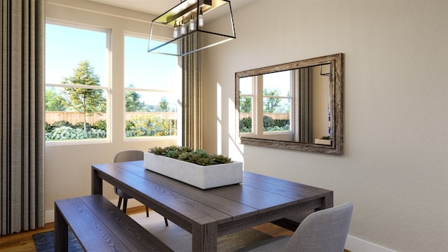 dining space with baseboards and wood finished floors