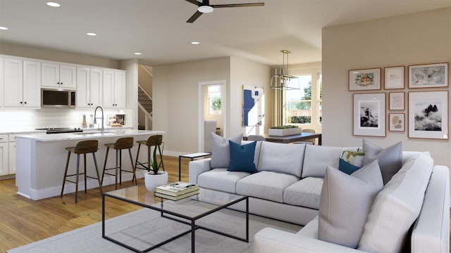 living area featuring light wood-type flooring, ceiling fan, and recessed lighting