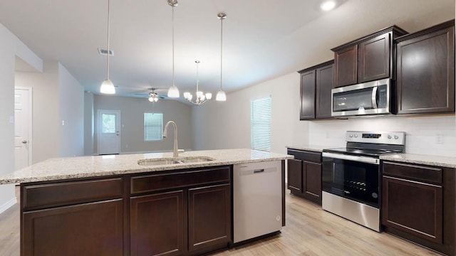 kitchen with stainless steel appliances, visible vents, light wood-style floors, a sink, and dark brown cabinetry