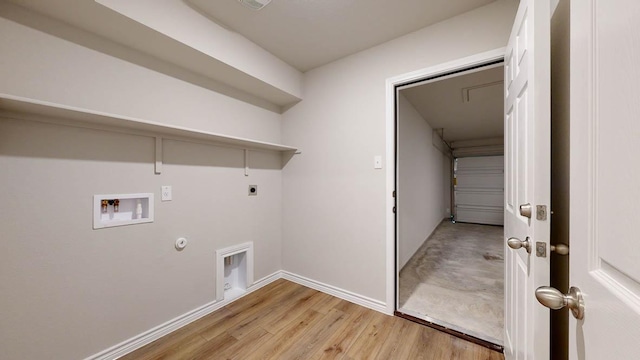 clothes washing area featuring washer hookup, hookup for a gas dryer, light wood-style floors, hookup for an electric dryer, and laundry area