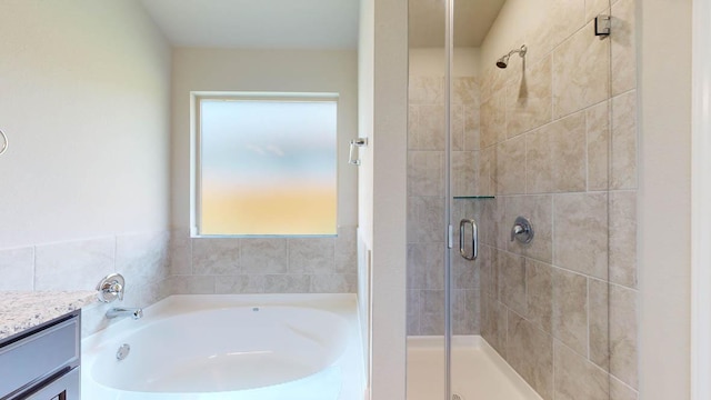 full bath featuring a stall shower, vanity, and a bath