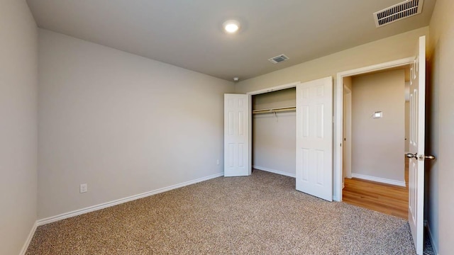 unfurnished bedroom featuring carpet, a closet, visible vents, and baseboards