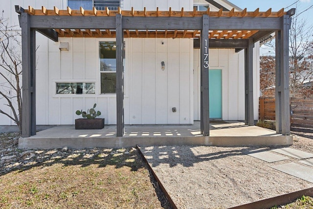 exterior space featuring board and batten siding and a pergola