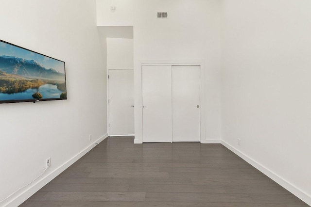 spare room featuring visible vents, baseboards, and wood finished floors