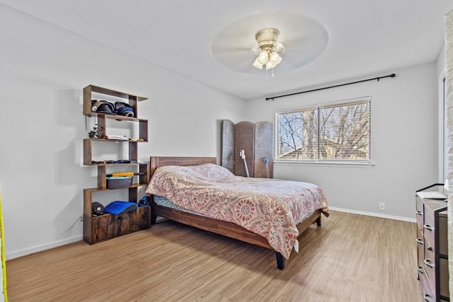 bedroom featuring ceiling fan, light wood-type flooring, and baseboards