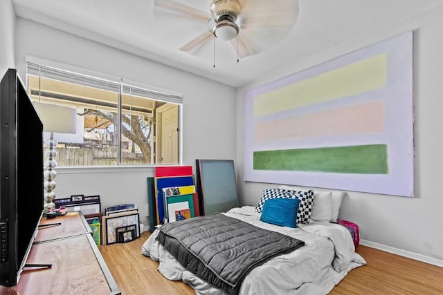 bedroom featuring a ceiling fan, baseboards, and wood finished floors