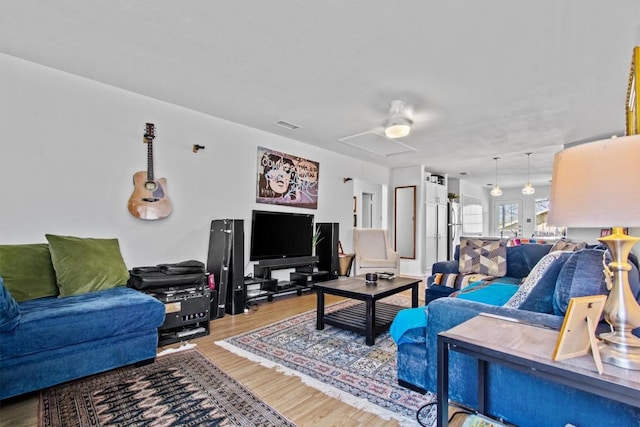 living area featuring visible vents and wood finished floors