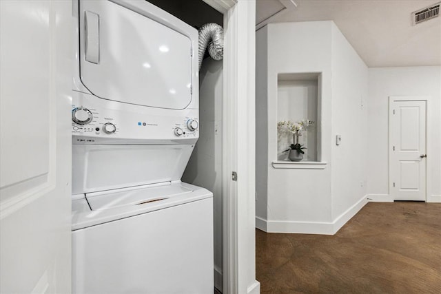 laundry area featuring laundry area, visible vents, baseboards, and stacked washing maching and dryer