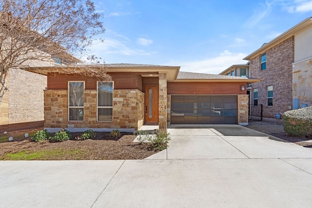 prairie-style home featuring a garage, driveway, and stone siding