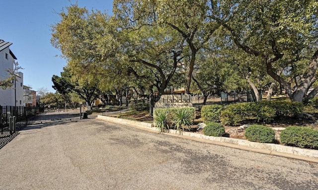 view of road featuring a gate, curbs, and a gated entry