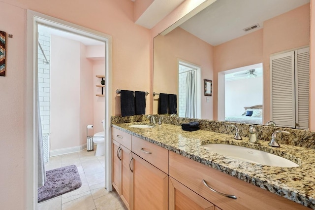 ensuite bathroom featuring visible vents, double vanity, a sink, and toilet