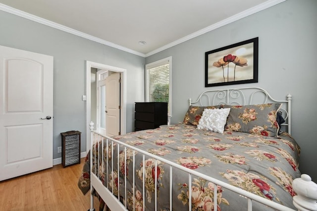 bedroom featuring ornamental molding, wood finished floors, and baseboards