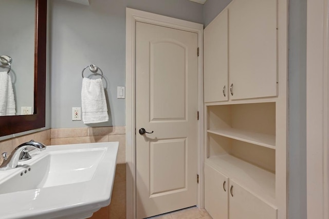 bathroom featuring tile walls, a sink, and tile patterned floors