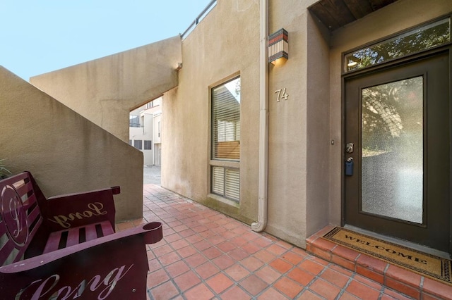 view of exterior entry featuring a patio area and stucco siding