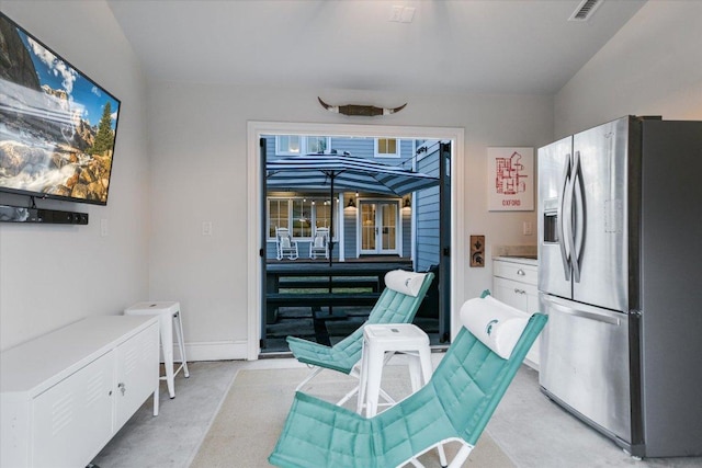 interior space with visible vents, stainless steel refrigerator with ice dispenser, white cabinetry, and baseboards