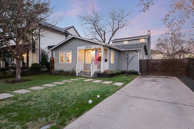 view of front of home featuring a gate, fence, and a front lawn