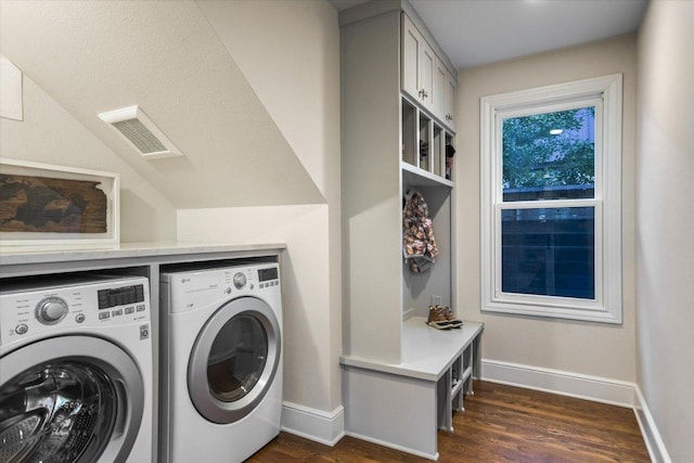 laundry room featuring washing machine and dryer, dark wood-type flooring, visible vents, baseboards, and cabinet space