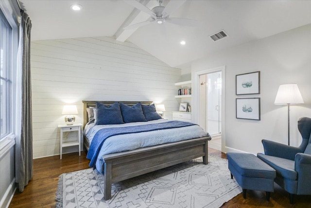 bedroom with vaulted ceiling with beams, wood walls, wood finished floors, visible vents, and a ceiling fan