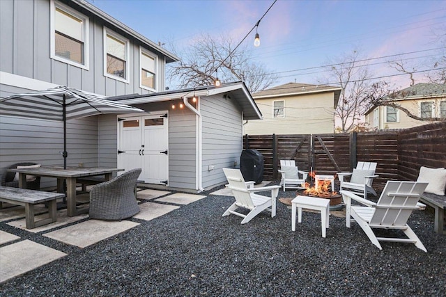 view of patio / terrace with outdoor dining space, fence, and a fire pit