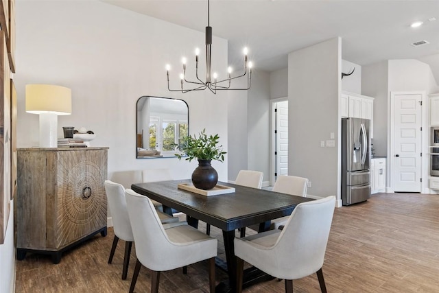 dining room with arched walkways, wood finished floors, and visible vents