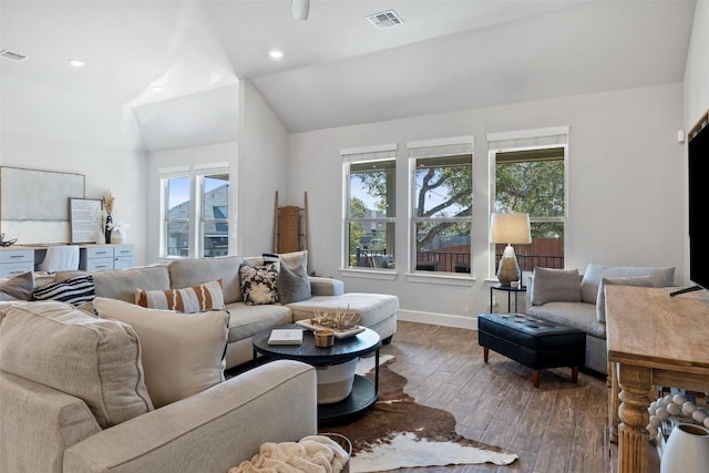 living area with lofted ceiling, a healthy amount of sunlight, visible vents, and wood finished floors