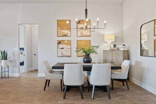 dining room with baseboards, a chandelier, and wood finished floors