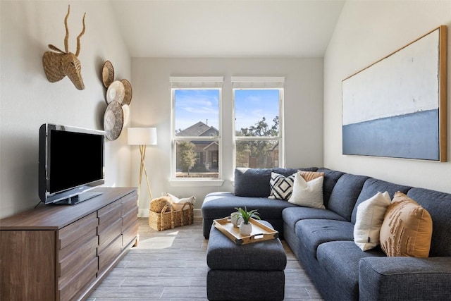 living area featuring lofted ceiling and light wood-style floors