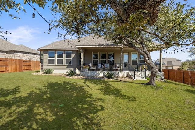 back of property featuring a fenced backyard, a porch, and a lawn