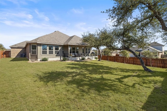 back of property with fence and a yard