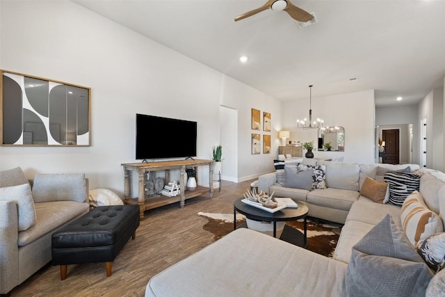 living room featuring baseboards, visible vents, wood finished floors, ceiling fan with notable chandelier, and recessed lighting