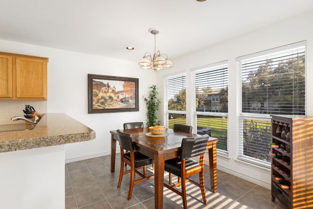 tiled dining room with a chandelier, recessed lighting, a sink, and baseboards