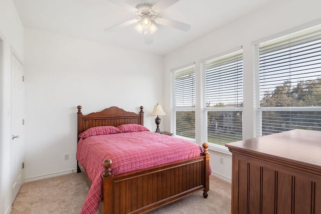 bedroom featuring ceiling fan, baseboards, and light colored carpet