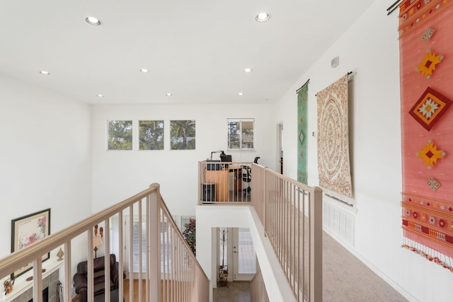 hallway with recessed lighting, carpet flooring, plenty of natural light, and an upstairs landing