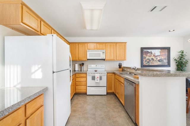 kitchen with white appliances, visible vents, a peninsula, light brown cabinets, and a sink