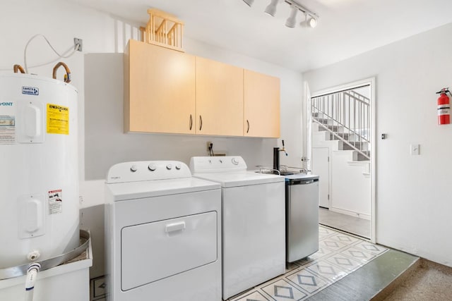 washroom with cabinet space, water heater, washer and clothes dryer, and track lighting