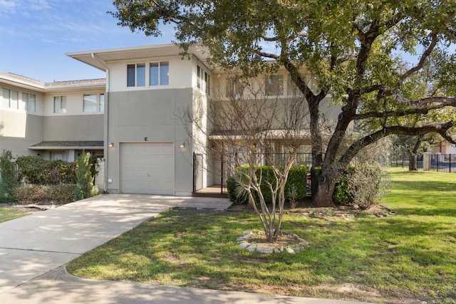 view of front of property with a front yard, concrete driveway, an attached garage, and stucco siding