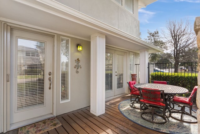 wooden terrace featuring outdoor dining space and french doors