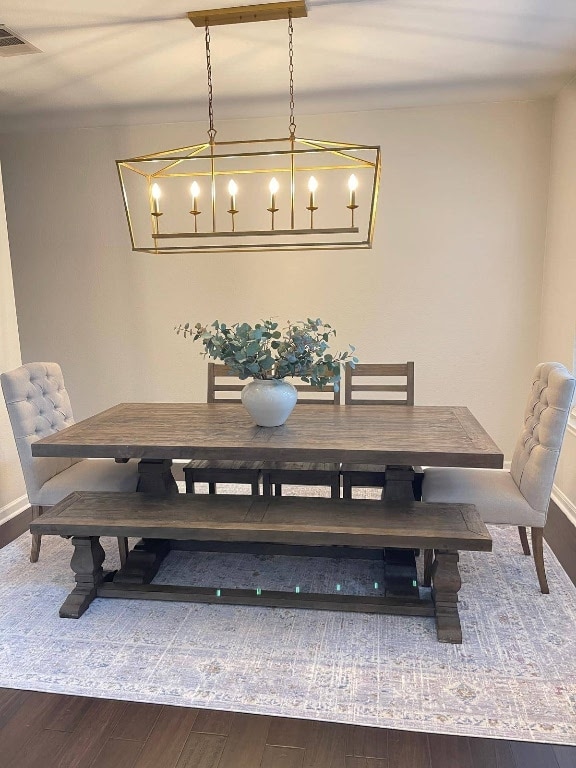 dining area featuring wood finished floors, visible vents, and baseboards