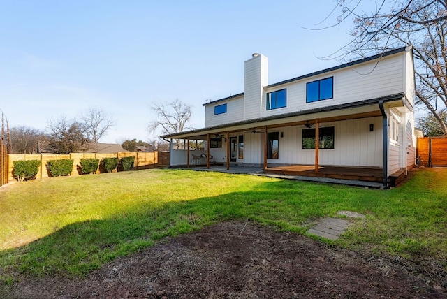 back of house with a yard, a chimney, a patio area, ceiling fan, and a fenced backyard