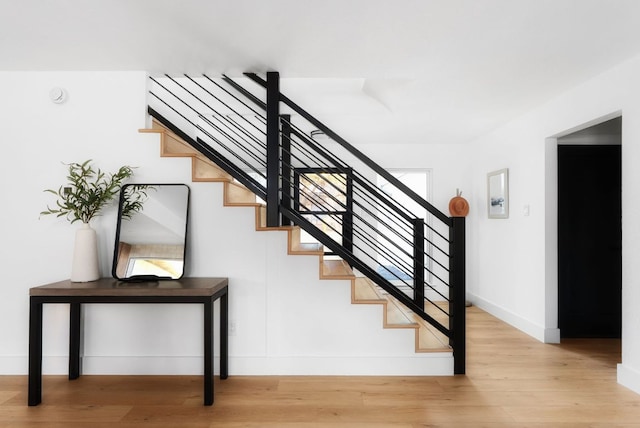 staircase with baseboards and wood finished floors