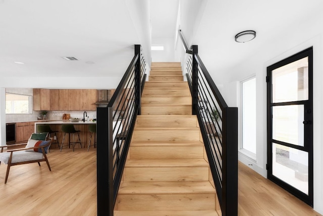 stairway featuring visible vents and wood finished floors