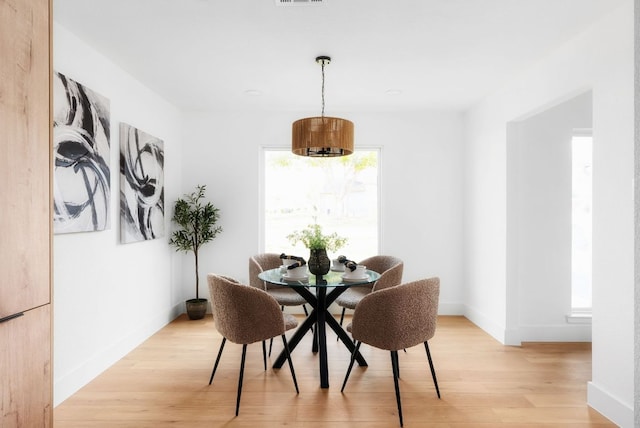 dining area featuring light wood-style flooring, visible vents, and baseboards