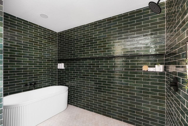 full bathroom with tiled shower, a freestanding tub, tile walls, and tile patterned floors