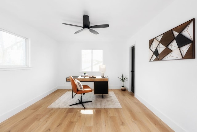 office with light wood finished floors, plenty of natural light, baseboards, and a ceiling fan